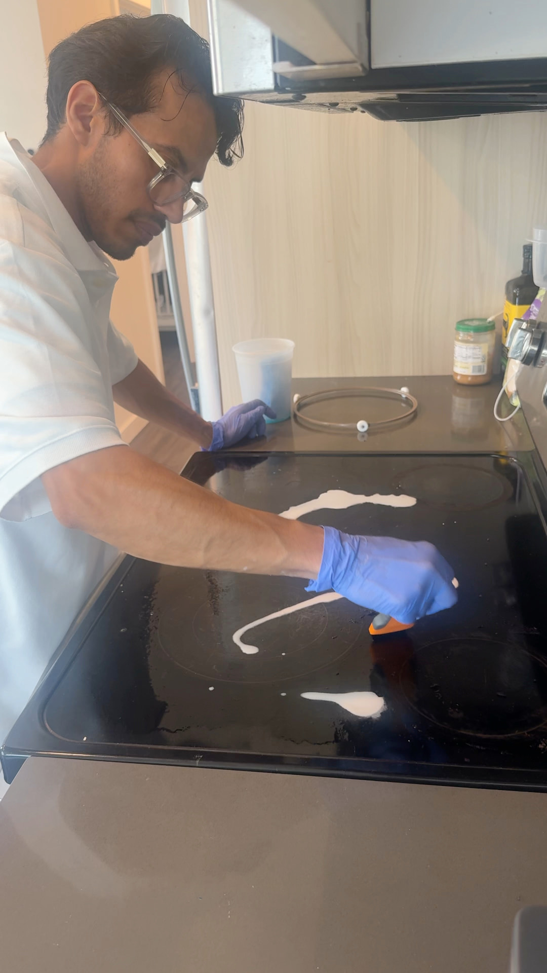 Cenlora cleaner scrubbing a black glass hob