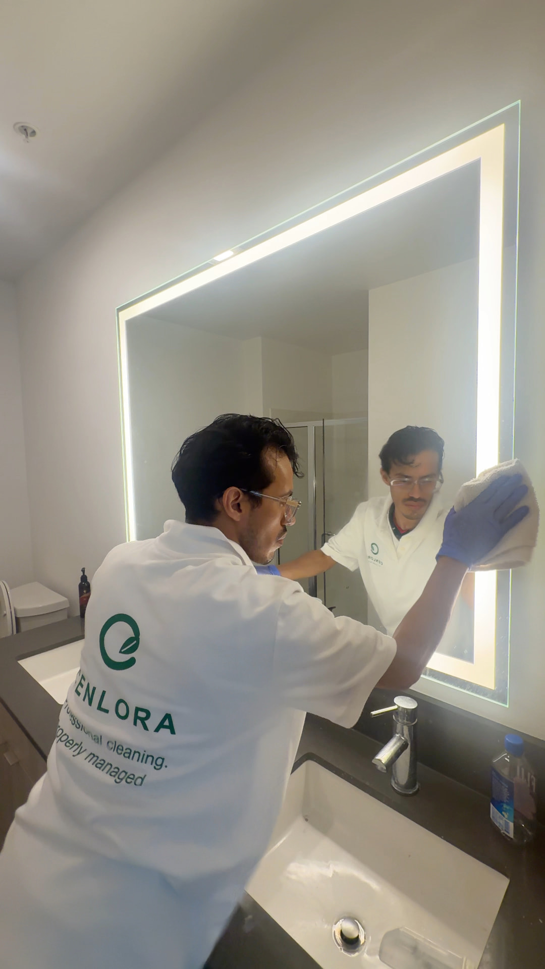 Cenlora cleaner cleaning a lit bathroom mirror